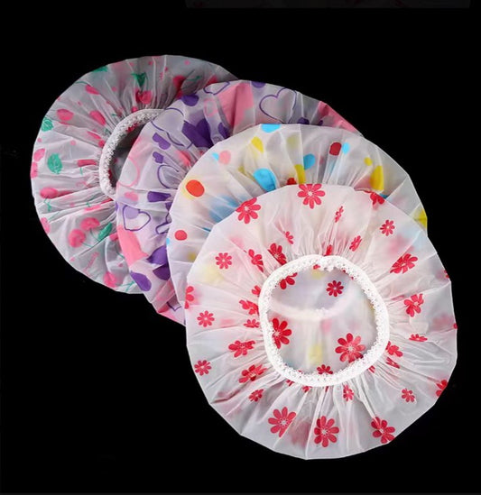 Vibrant, patterned shower caps in various designs including floral, polka dots, and abstract prints. The caps are made of soft, waterproof material to protect hair during bathing.