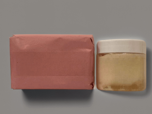 Elegant bath set: pink soap bar and golden soap dish, presented on gray background.